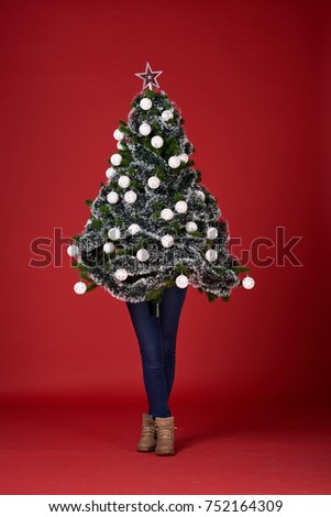 Girl holding Christmas tree. Red background