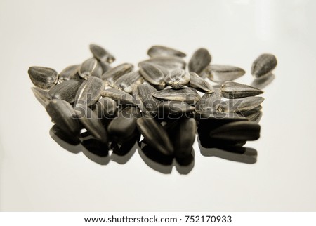 A bunch of sunflower seeds lies on a gray background, the front view