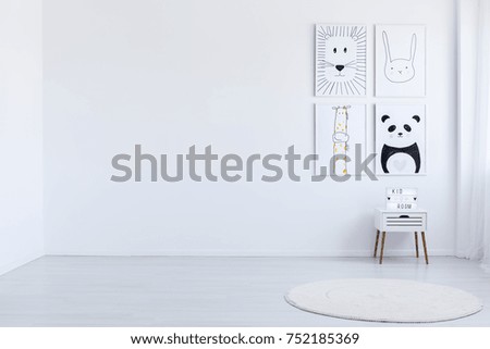 Copy space of white spacious autistic kid's room with drawings, white cabinet and carpet