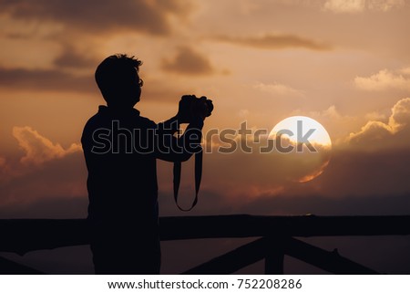 silhouette of man photographer take photos with sunset background