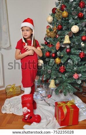 Girl in front of the fir tree with gifts for Christmas
