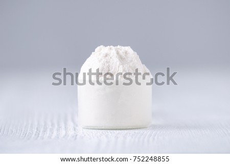 a scoop with white powder on gray background, selective focus Royalty-Free Stock Photo #752248855