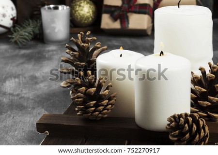 Burning candles and Christmas attributes on a dark background