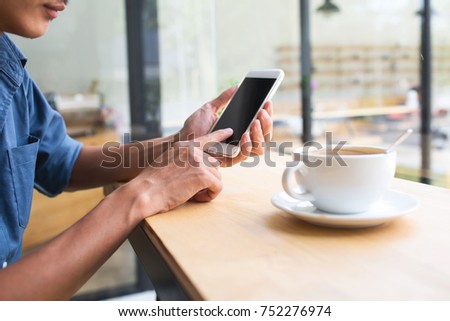 Asian business man using mobile application in coffee shop with vintage tone picture style in the morning.