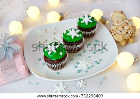 a group of muffins decorated with sugar snowflakes, against a christmas background