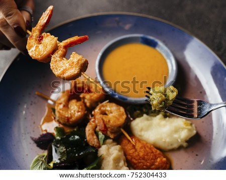 Asian sea food served in big blue dish on dark stone table