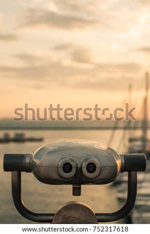Sunrise in the port through binoculars at the viewing platform view of the sea with yachts