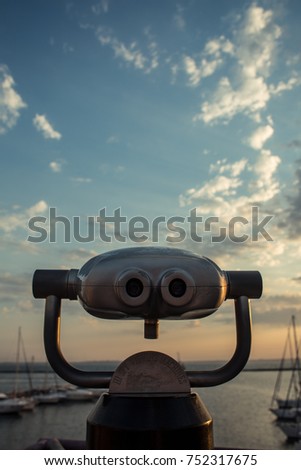 Sunrise in the port through binoculars at the viewing platform view of the sea with yachts