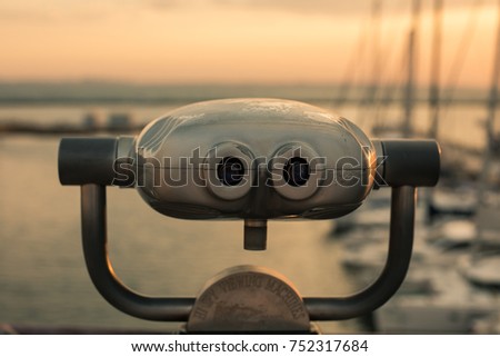 Sunrise in the port through binoculars at the viewing platform view of the sea with yachts overlooking the horizon