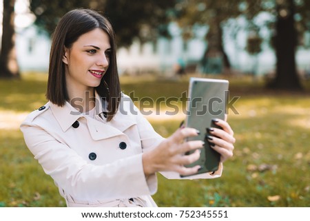 Attractive young girl taking selfie with her tablet.