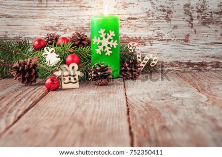 Christmas background with Christmas tree branches on a wooden surface. Candles, pine cone, snowflakes and red christmas balls. Empty wooden deck table, ready for product montage.