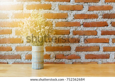 beautiful little tree on wooden table and brick wall background