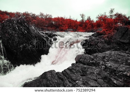 Waterfall in a mountainous area with red trees
