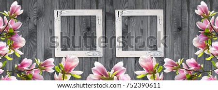 Two retro empty photo frames with magnolia flowers on background of shabby wooden planks in rustic style