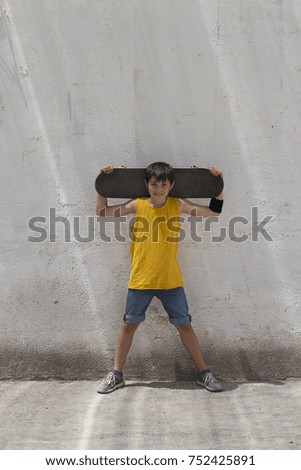 Close-up of a teenage boy carrying skateboard and smiling