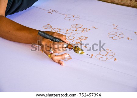 sketching freehand with canting tools and hot wax to create a traditional Batik Canting, Making Batik 