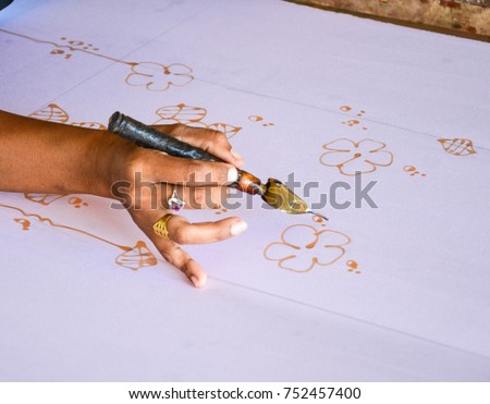 sketching freehand with canting tools and hot wax to create a traditional Batik Canting, Making Batik 