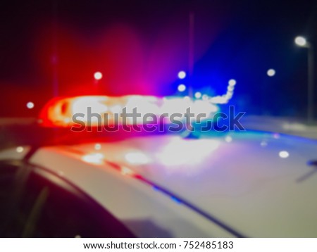 Red and blue Lights of police car in night time. Night patrolling the city. Abstract blurry image.