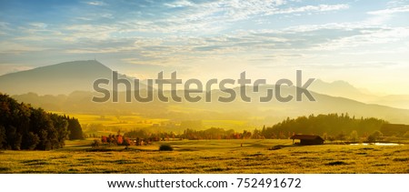 Breathtaking lansdcape of Austrian countryside on sunset. Dramatic sky over idyllic green fields of Anstrian Central Alps on early autumn evening. Royalty-Free Stock Photo #752491672