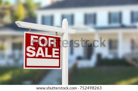Home For Sale Real Estate Sign in Front of Beautiful New House. Royalty-Free Stock Photo #752498263