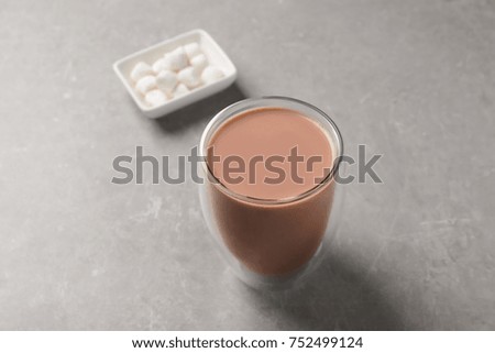Glass with delicious cocoa drink on grey background