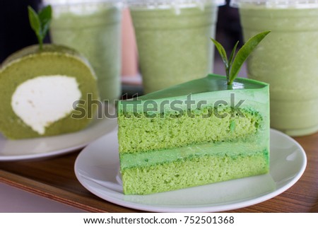 Japannese  dessert - Japannese matcha green tea cake on white disk and wood plate with green tea milk and roll cake background