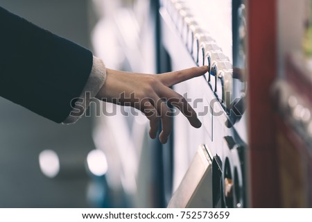 Woman buying with a vending machine Royalty-Free Stock Photo #752573659