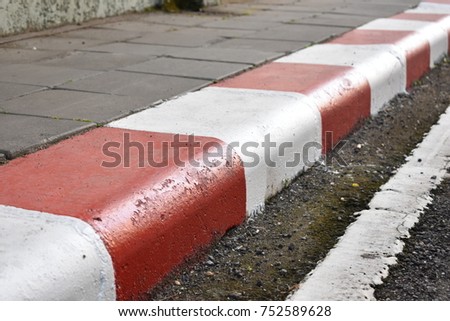 Red and white at edge of the footpath is symbol not parking