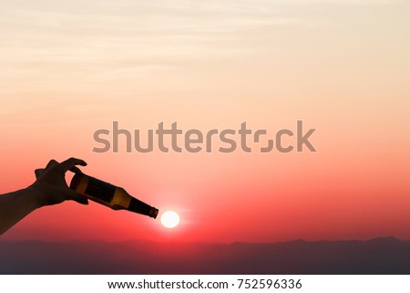 Shadow image.The young man drank beer until dawn to watch the sun rising on the horizon.
A bottle of wine along the line of the sun in the evening. Ideas to keep warm and memorable before sunset.