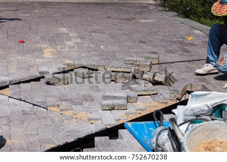 Worker paving concrete block flooring pathway