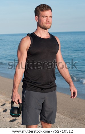 Man Training with Kettle bell at beach