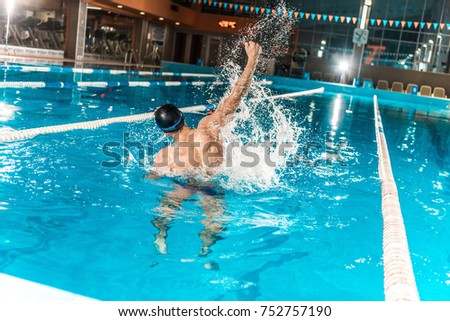 back view of winning swimmer gesturing in competition swimming pool  Royalty-Free Stock Photo #752757190
