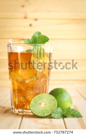 ice tea with slice of lemon in glass on the wooden background