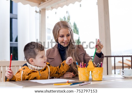 mother and son in the restaurant painted pencils before eating