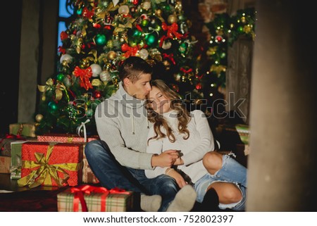 Young couple resting near the fireplace in the new year/Christmas