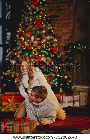 Young couple resting near the fireplace in the new year/Christmas