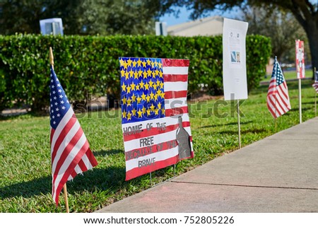 MISSOURI CITY, TEXAS, USA - November 10, 2017: Flags of the United States and patriotic posters drawn by students erected near Sienna Crossing Elementary school to celebrate Veterans Day