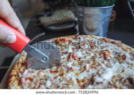 The man cuts the cooked pizza special round pizza knife