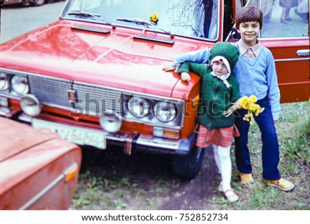 USSR, LENINGRAD - CIRCA 1982: Vintage photo of kids posing at family red car