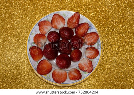 
Strawberries cut on bright golden background