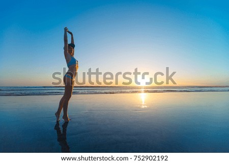 female in amazing sunset on low tide with reflected cloud