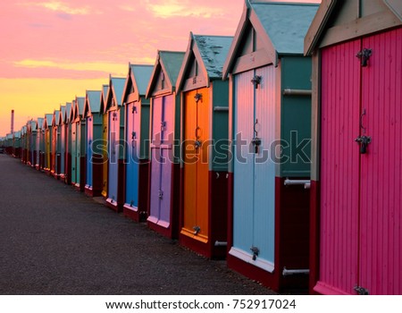 a line of 30 beach huts with a diminishing perspective, the nearer beachhuts are big, lamp post and promenade, brighton seafront Royalty-Free Stock Photo #752917024
