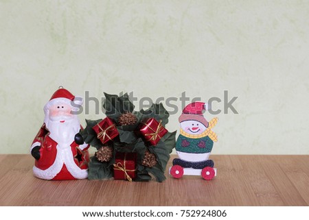 Santa Claus toy surrounded by presents, green wreath and snowman