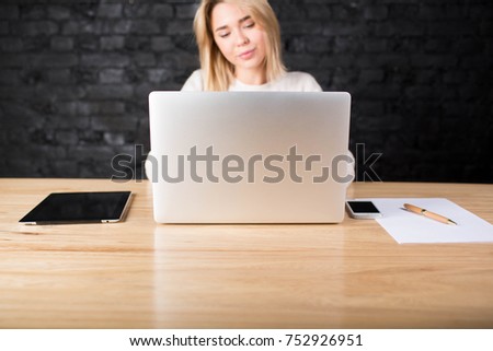 Portable laptop computer with copy space for your advertising text lying on a wooden table with digital tablet , mobile phone and paper documents. Businesswoman at the table with net-book, touch pad. 