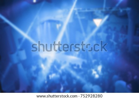 Blurred for background. night club party. Night club dj party people enjoy of music dancing sound with colorful light with Smoke Machine and lights show. Hands up in earth.
