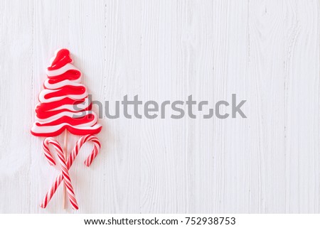 Christmas candy cane lollipop Christmas tree over white wooden textured background 