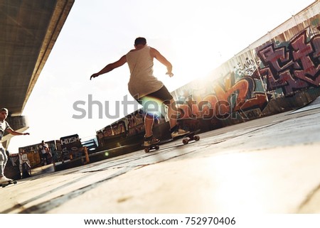 Find your freedom! Full length rear view of young man skateboarding while hanging out at the skate park outdoors
