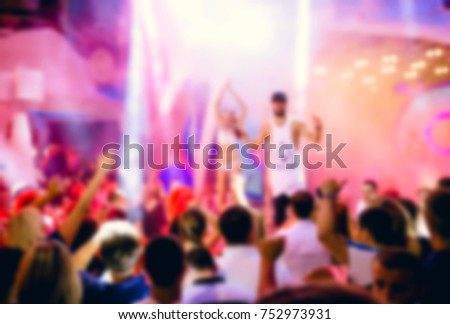 Blurred for background. night club party. Night club dj party people enjoy of music dancing sound with colorful light with Smoke Machine and lights show. Hands up in earth