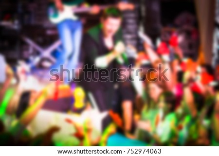 Blurred for background. Artist performs songs from stage during concert at nightclub. Artist on club stage during night party.