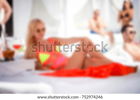 Blurred for background. pool beach club. Men and woman relaxing in luxury beach resorts during summer holidays. boy and girl has rest on day lounge party at elite summer resorts